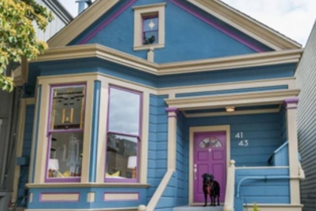 旧金山Sunny Victorian with Stunning View and Wraparound Deck的蓝色的房子,外面有一只狗