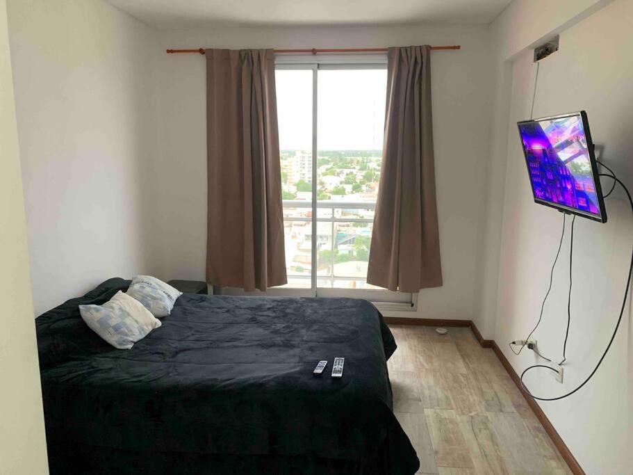 圣洛伦索Dpto temporal amueblado con yacuzzi的一间卧室设有一张带电视和窗户的床。
