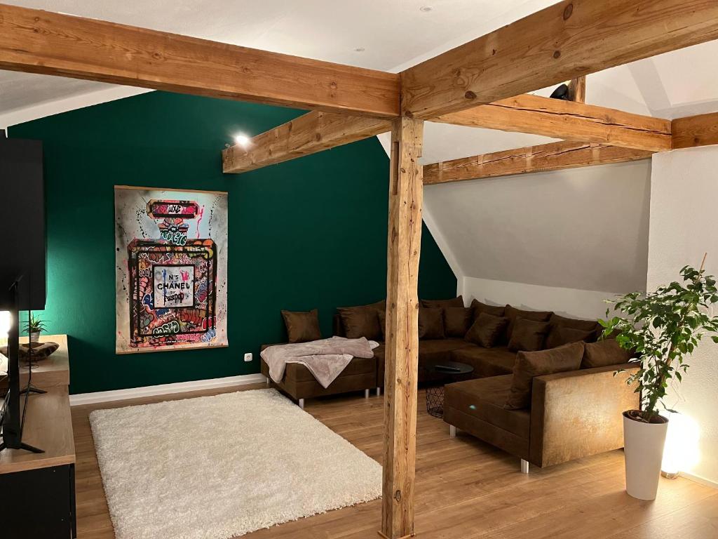 库姆巴赫Super Lodge Kulmbach的客厅设有绿色的墙壁和沙发