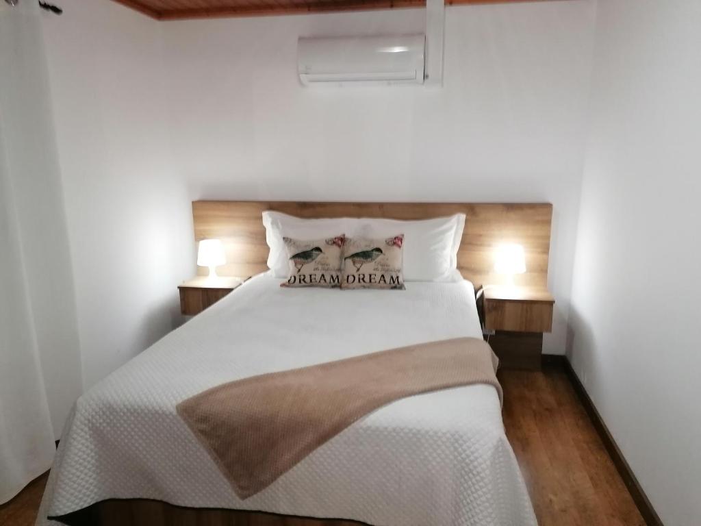 马达莱纳A Casa da Formosinha的卧室配有带两盏灯的白色床