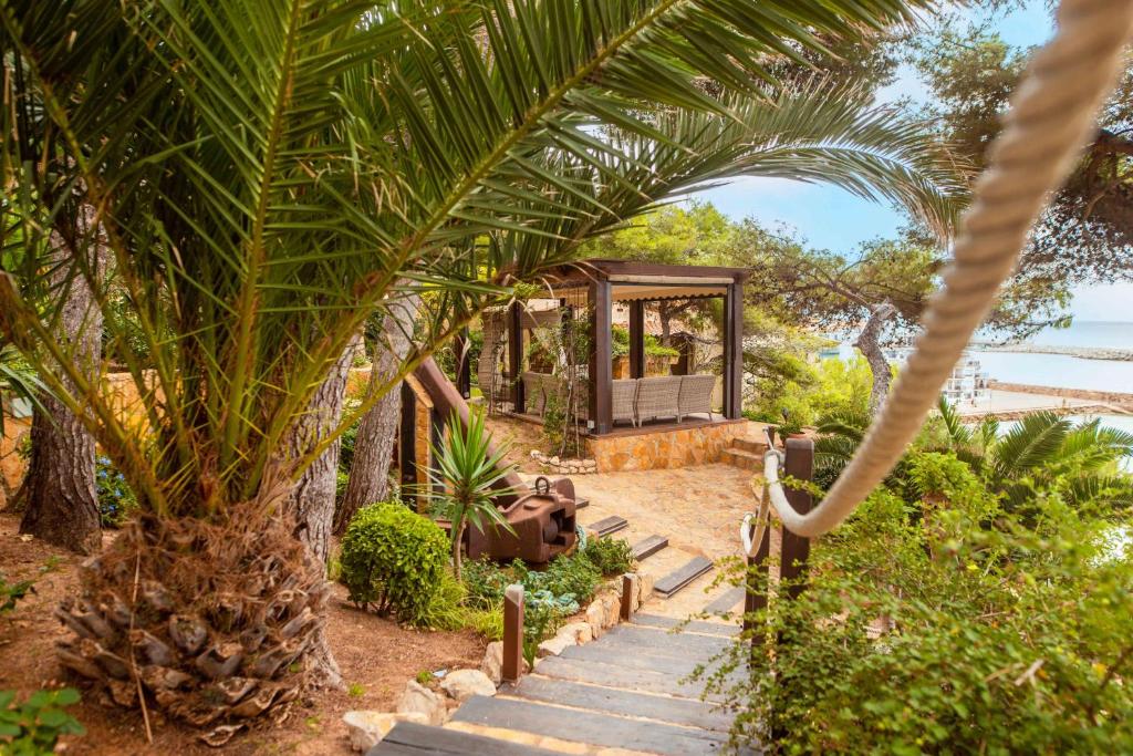 罗达德瓦拉HOTEL La Estrella del Mediterráneo的一座带凉亭和棕榈树的房子