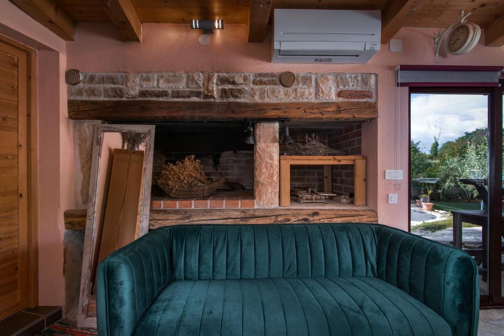 班约勒Istrian Tavern next to the Pool的带壁炉的客房内的绿色沙发