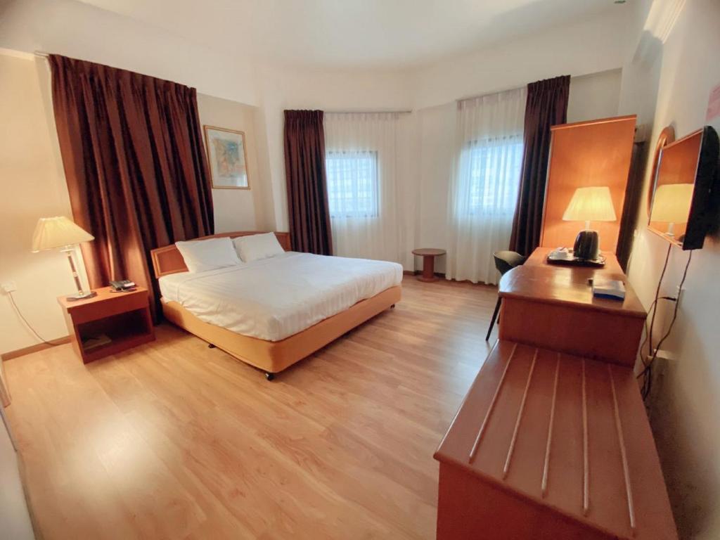 诗巫Kawan Hotel的配有一张床和一张书桌的酒店客房