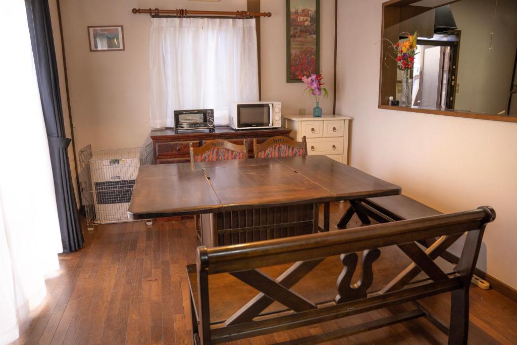诹访市一組貸切宿 岡村 弐番館 一棟まるまる貸切的一张木桌,在房间内配有长凳