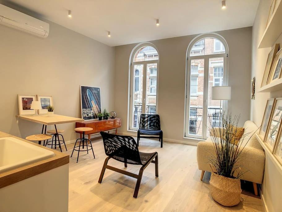 鲁汶Nieuw appartement in Leuven centrum!的客厅配有椅子和桌子,设有窗户