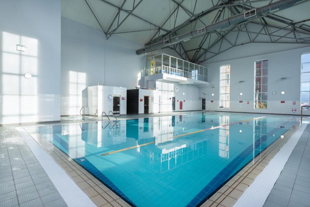 奥兰莫尔奥兰莫尔戈尔韦马德龙酒店及休闲中心的大楼内一个蓝色的大型游泳池