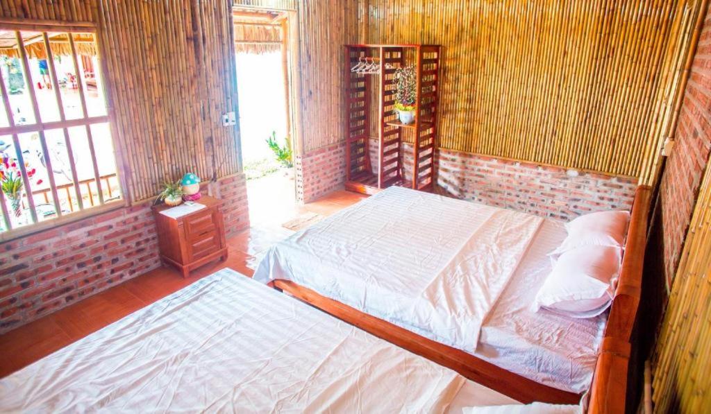 宁平Ninh Binh Bungalow Homestay的一间卧室设有两张床和窗户。