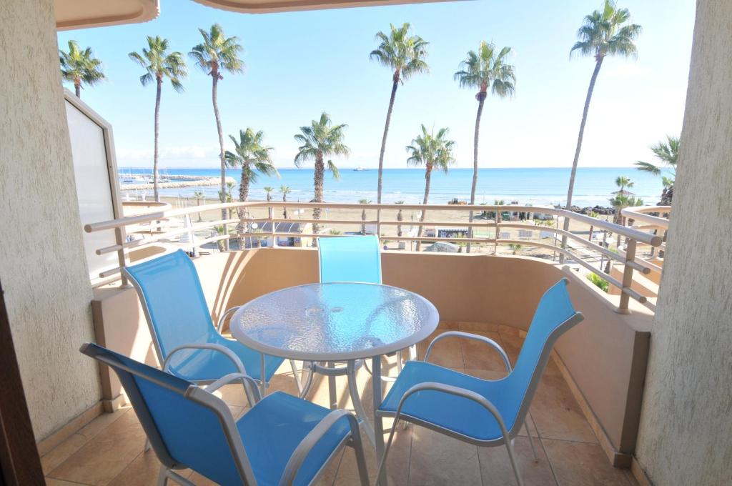 拉纳卡Ithaki Phinikoudes Apartment No. 201的海滩景阳台配有桌椅