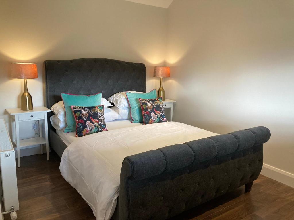 SallinsClara Lodge的一间卧室配有一张大床和灰色床头板