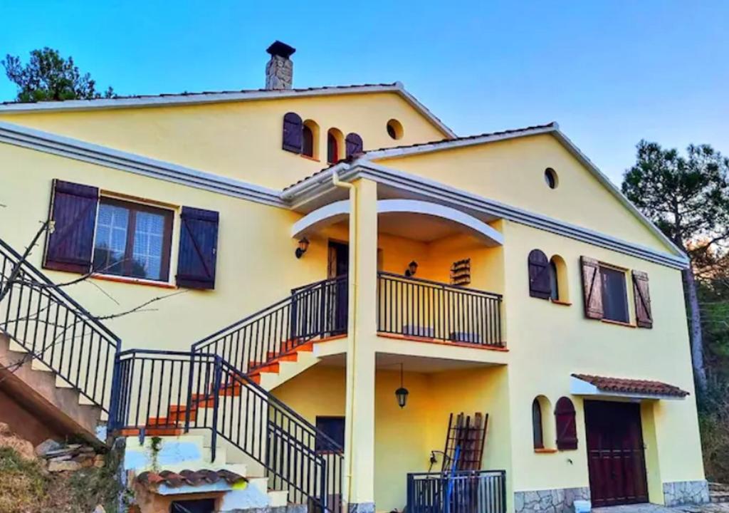 MarganellCasa Donaire, alojamiento turístico的前面有楼梯的大型黄色房子