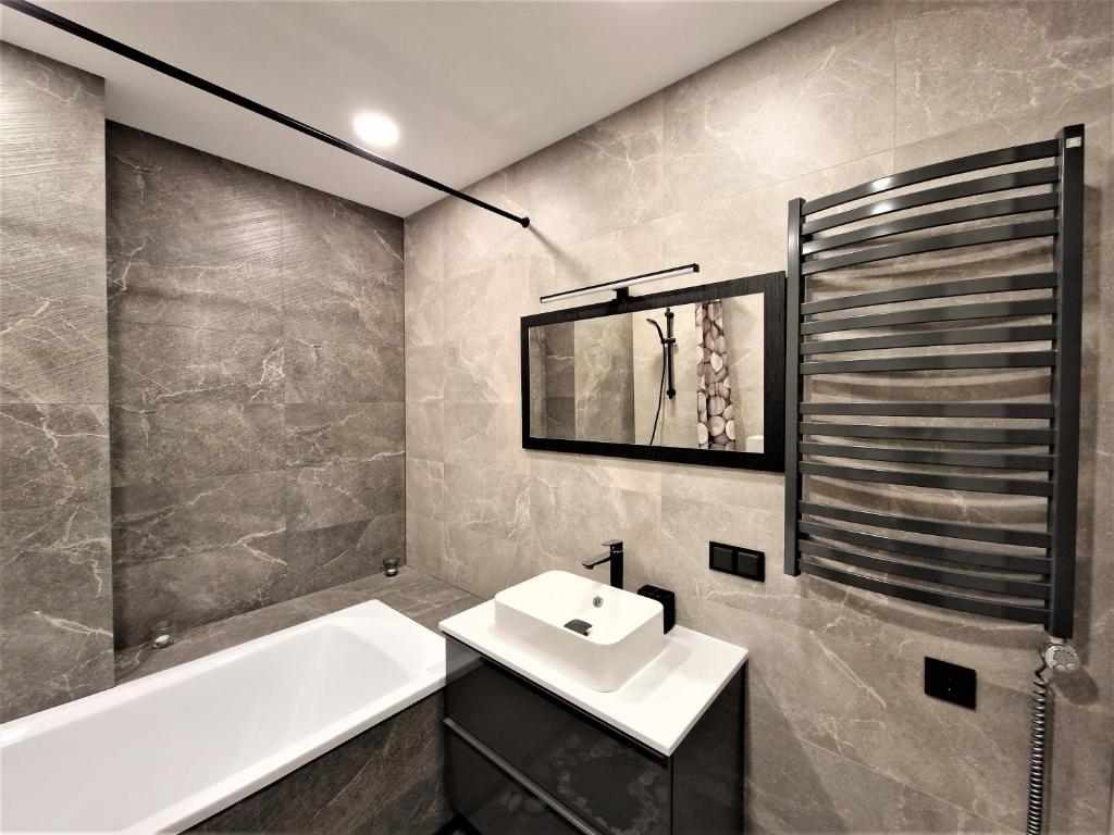 维尔纽斯Aurea apartment的浴室配有盥洗盆和浴缸。
