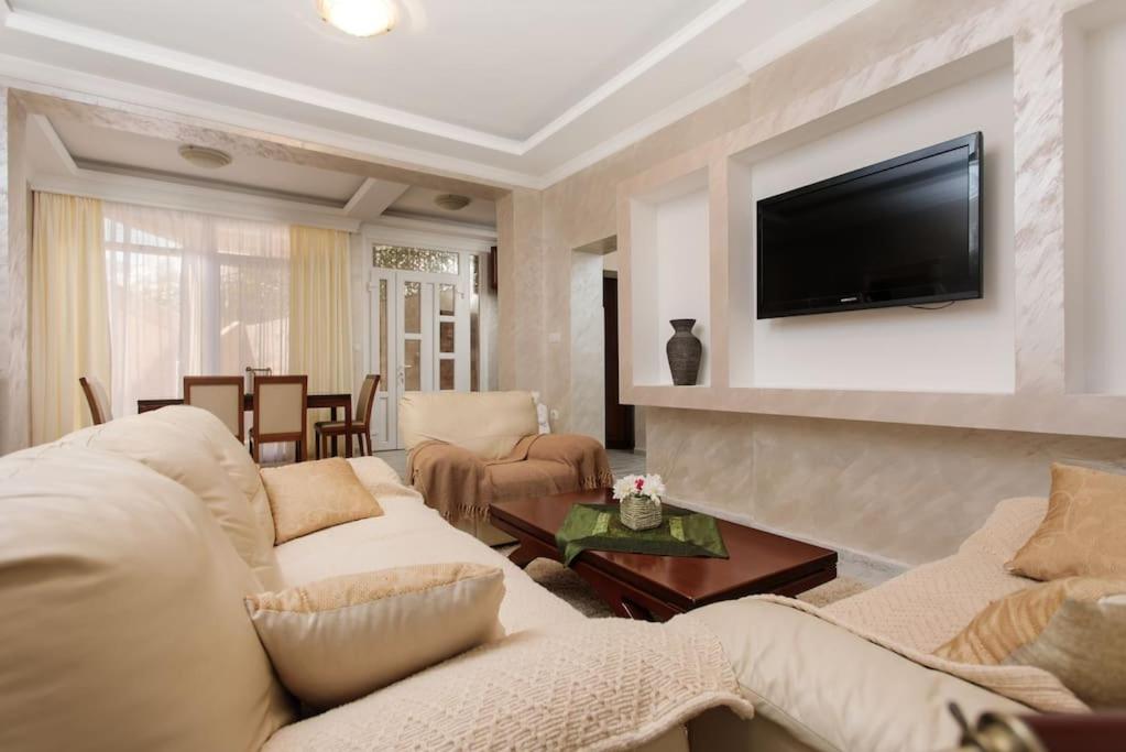 科托尔Summer retreat的客厅配有2张白色沙发和1台电视