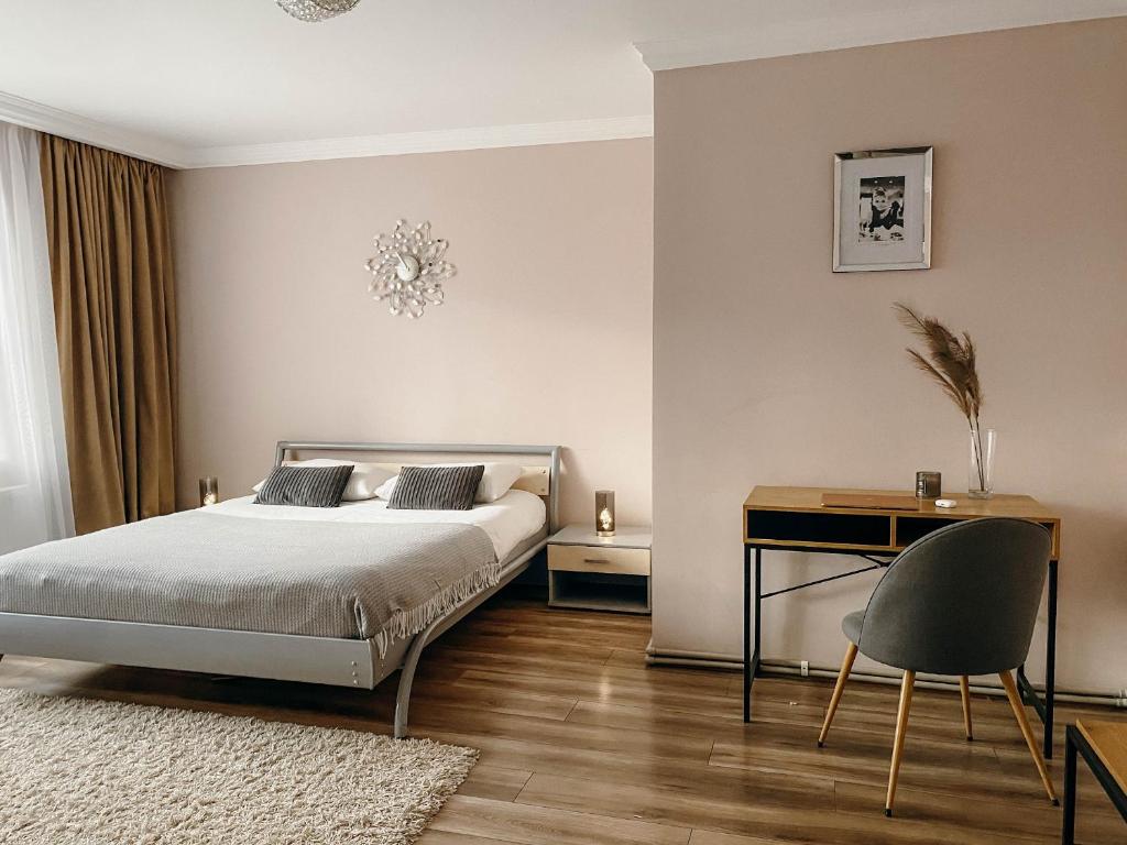 捷尔诺波尔Апартаменти в центрі Тернополя的一间卧室配有一张床、一张桌子和一把椅子