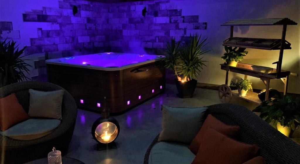 La BaffeLa Chambre Enchantée的客房内的按摩浴缸配有紫色灯