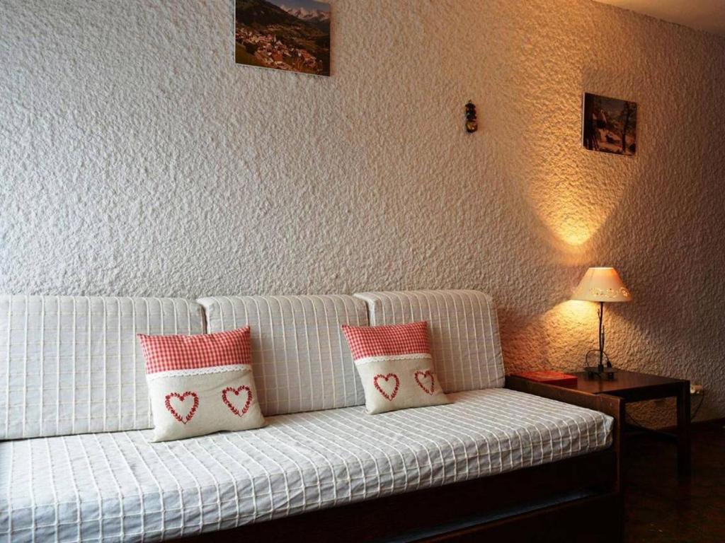 大博尔南Appartement Le Grand-Bornand, 1 pièce, 4 personnes - FR-1-241-80的白色的沙发,上面有红色和白色的枕头