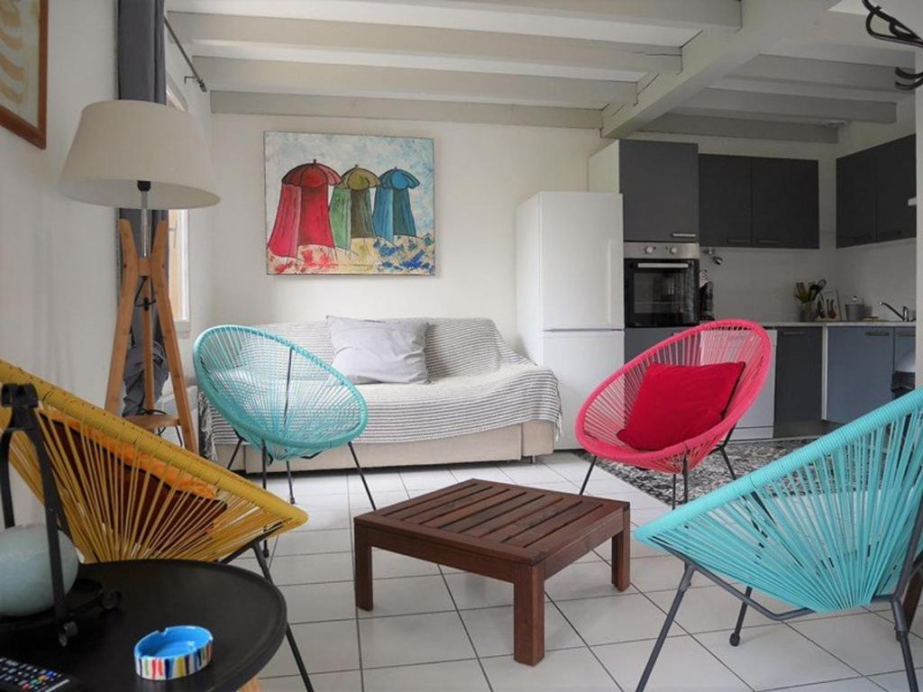 卡布勒通Villa Capbreton, 3 pièces, 4 personnes - FR-1-413-79的客厅配有色彩缤纷的椅子和1张床