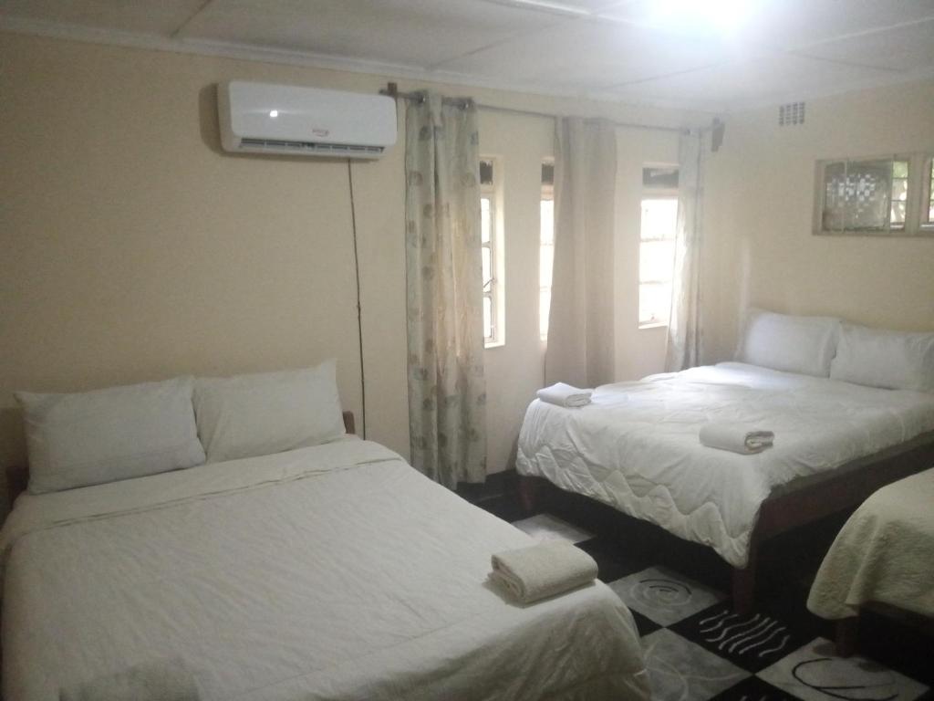 NamzungaBlue Waxbill Lodge的客房设有两张床和窗户。