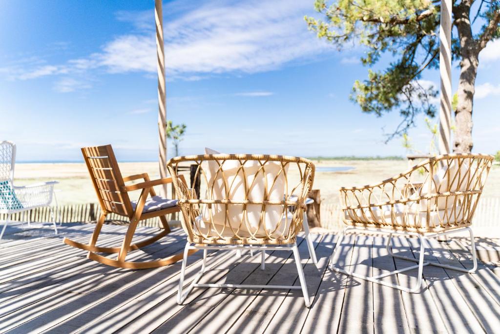 滨海拉特朗什勒贝尔维尤露营假日公园的海滩甲板上的两把椅子和一张吊床