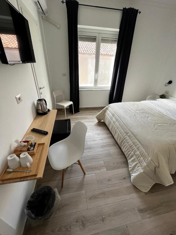 卡塔尼亚Dimora sicula guest house的一间卧室配有一张床和一张桌子及椅子