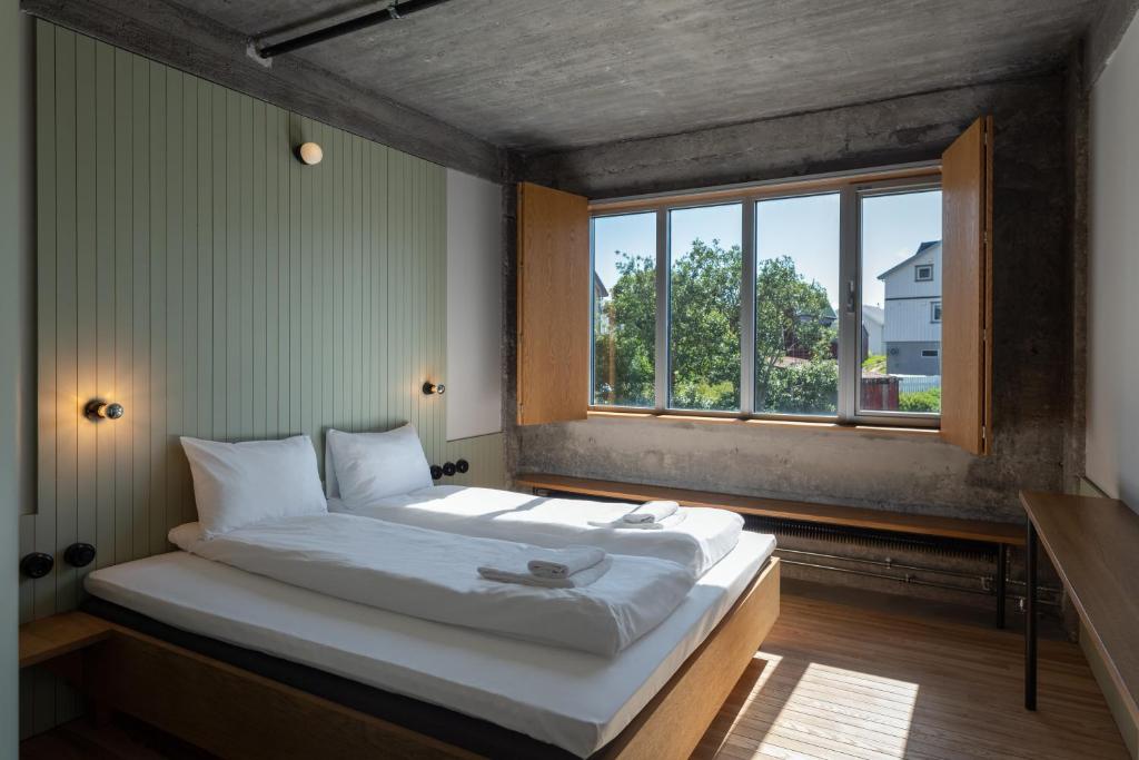 亨宁斯韦尔Trevarefabrikken的窗户客房内的一张大床