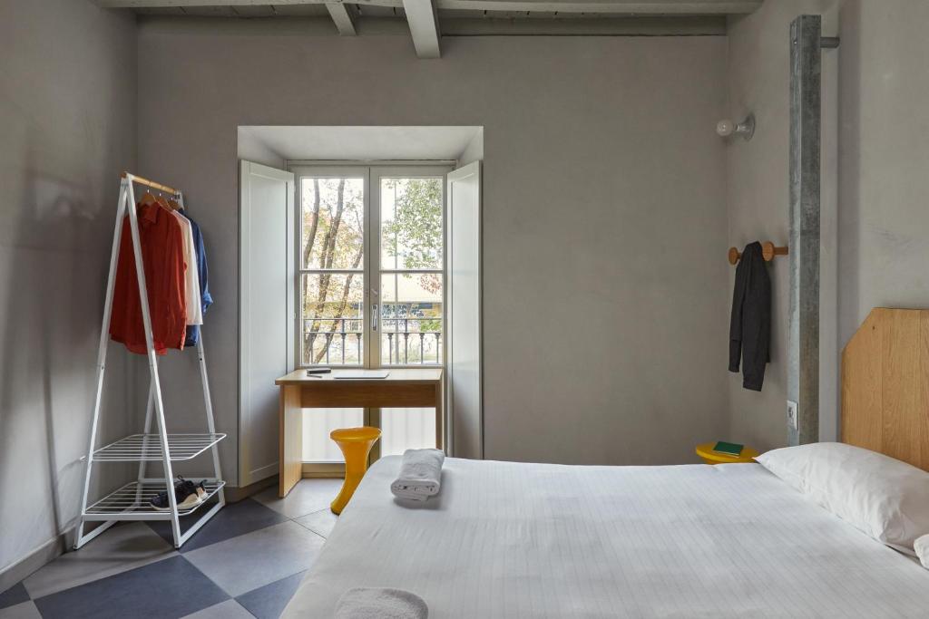 米兰Combo Milano的一间卧室配有一张床、一个窗口和一张书桌