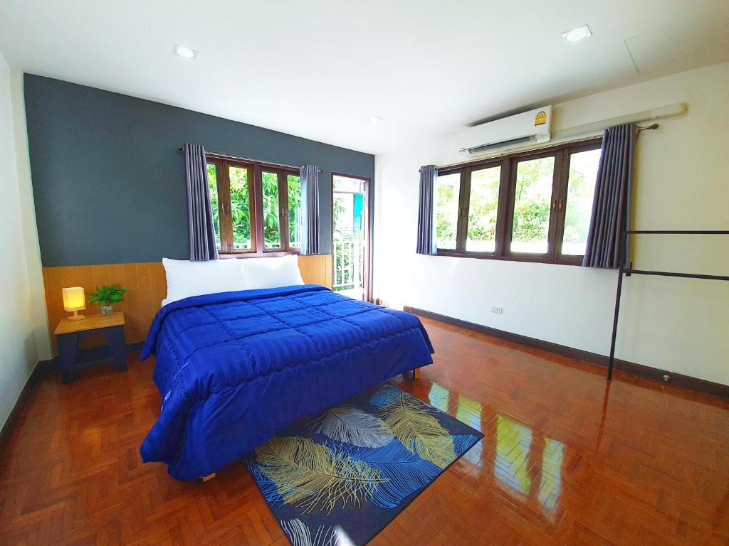 清迈Doodle Lodge Chiang Mai的一间卧室配有一张带蓝色棉被的床