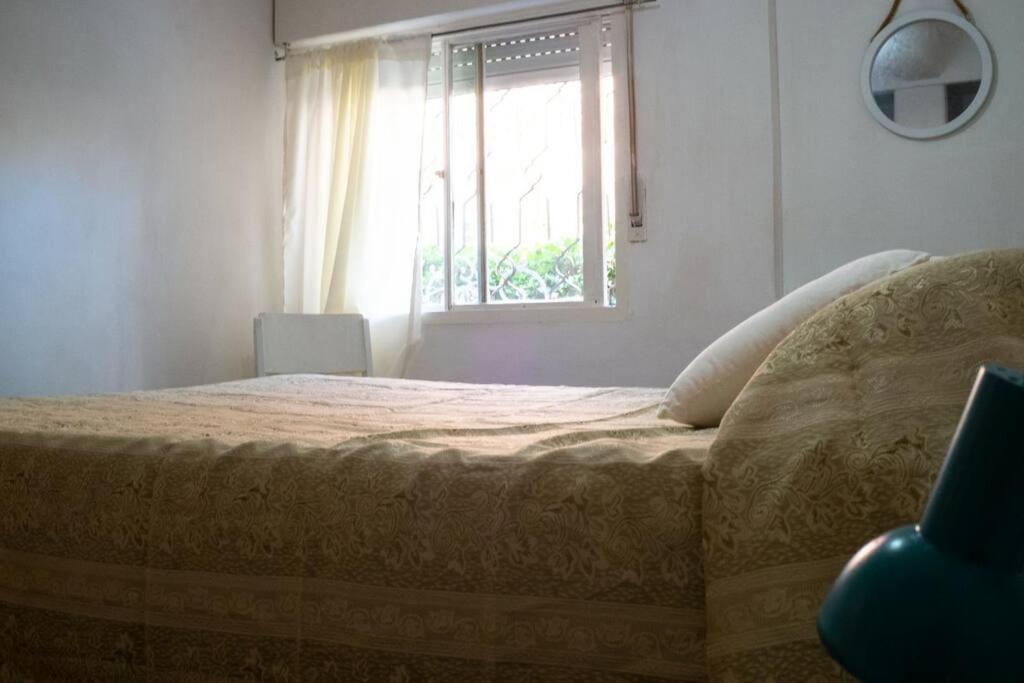 皮里亚波利斯Casa para 4 pers. con entrada de auto y parrillero的一间卧室设有一张大床和一个窗户。