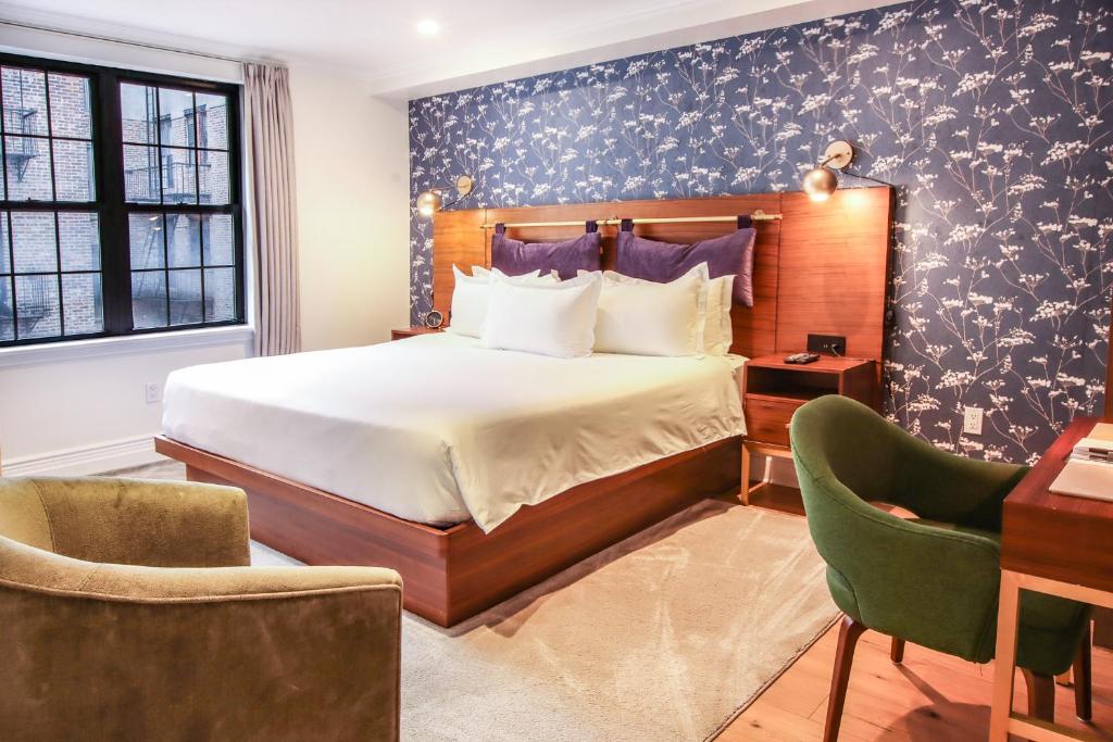 纽约Hotel Scherman的卧室配有一张床、一张桌子和椅子