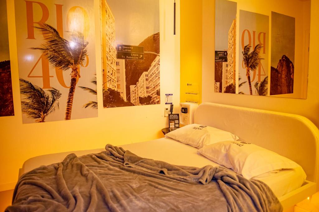 圣玛丽亚Motel Itapuã III Fx Rosário do Sul的墙上贴有海报的房间的一张床位
