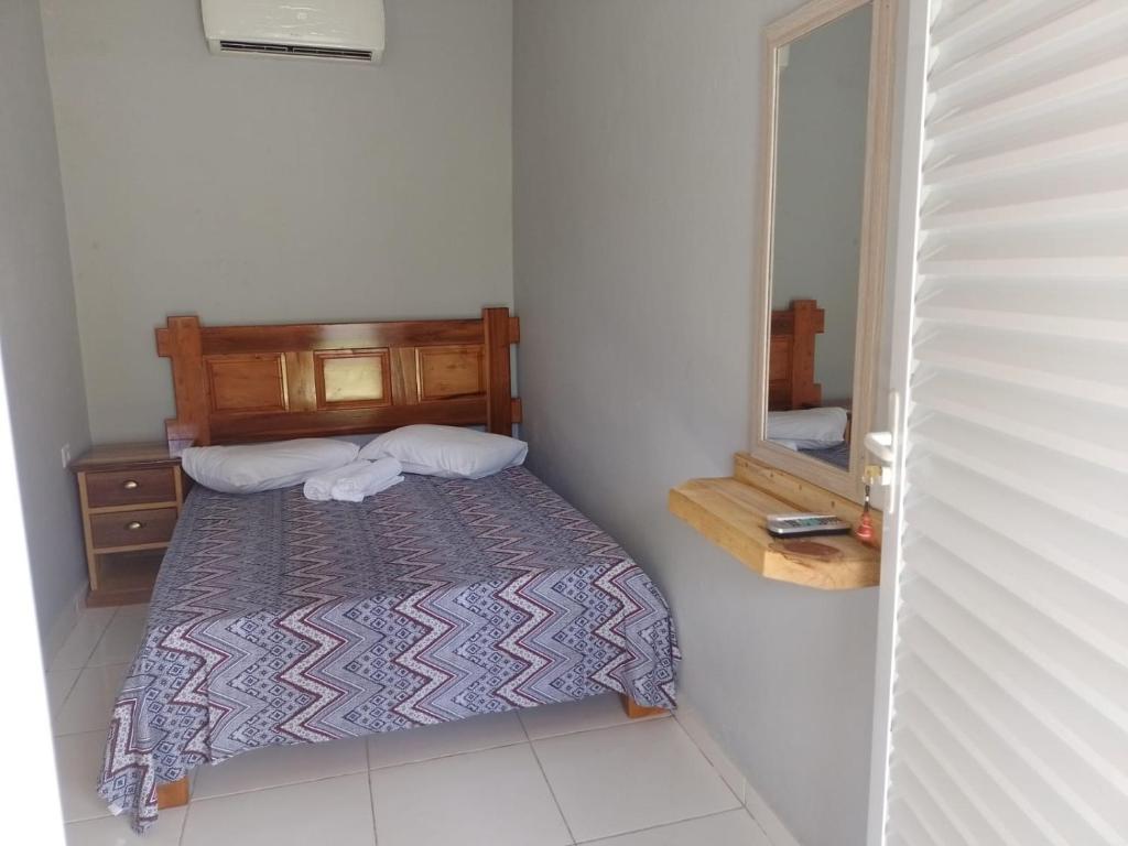 卡纳内亚Pousada do Alemão - Cananéia的一间小卧室,配有一张床和镜子