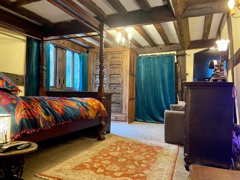 BodenhamThe Vauld, 2 bedroom suite with Bed and Breakfast的一间设有床铺的卧室,位于带蓝色窗帘的房间