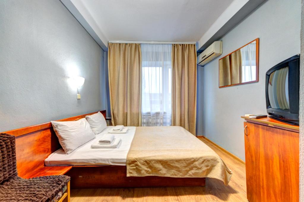 基辅豪罗斯维斯基酒店的一间酒店客房,配有一张床和一台电视