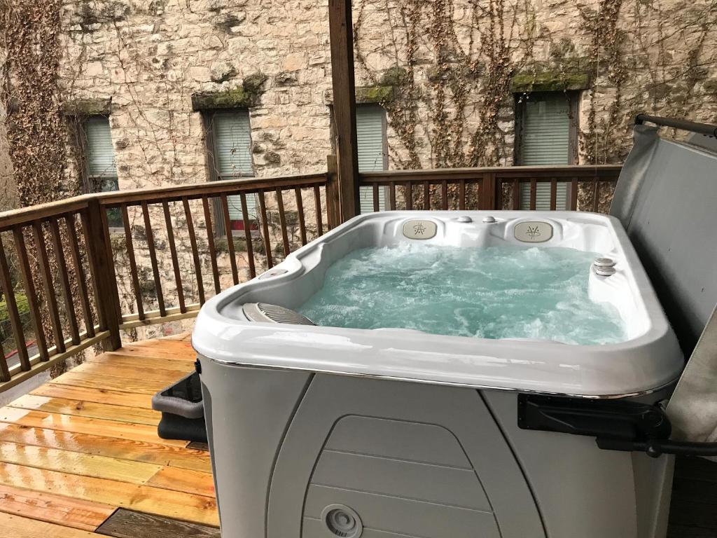 尤里卡斯普林斯Private Luxury Suite with Hot Tub Downtown Eureka Springs的阳台甲板上的热水浴池
