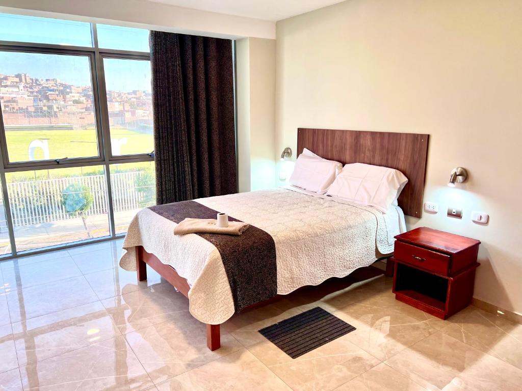 La ApachetaHOTEL DORADO AREQUIPA的一间卧室设有一张床和一个大窗户