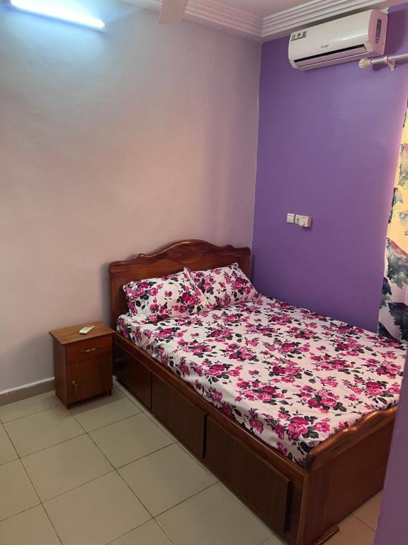 瓦加杜古Ouedraogo Property Management的一间卧室配有一张带花卉棉被的床
