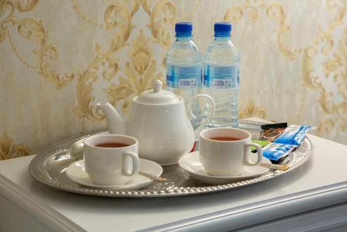 纳曼干ORZU HOTEL的托盘,内含2杯茶和2瓶水