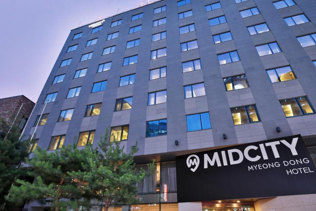 首尔Hotel Midcity Myeongdong的前面有标志的大建筑