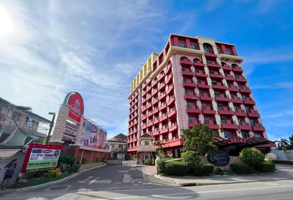 麦克坦麦克坦皇冠丽晶套房酒店的街道边高大的红色建筑
