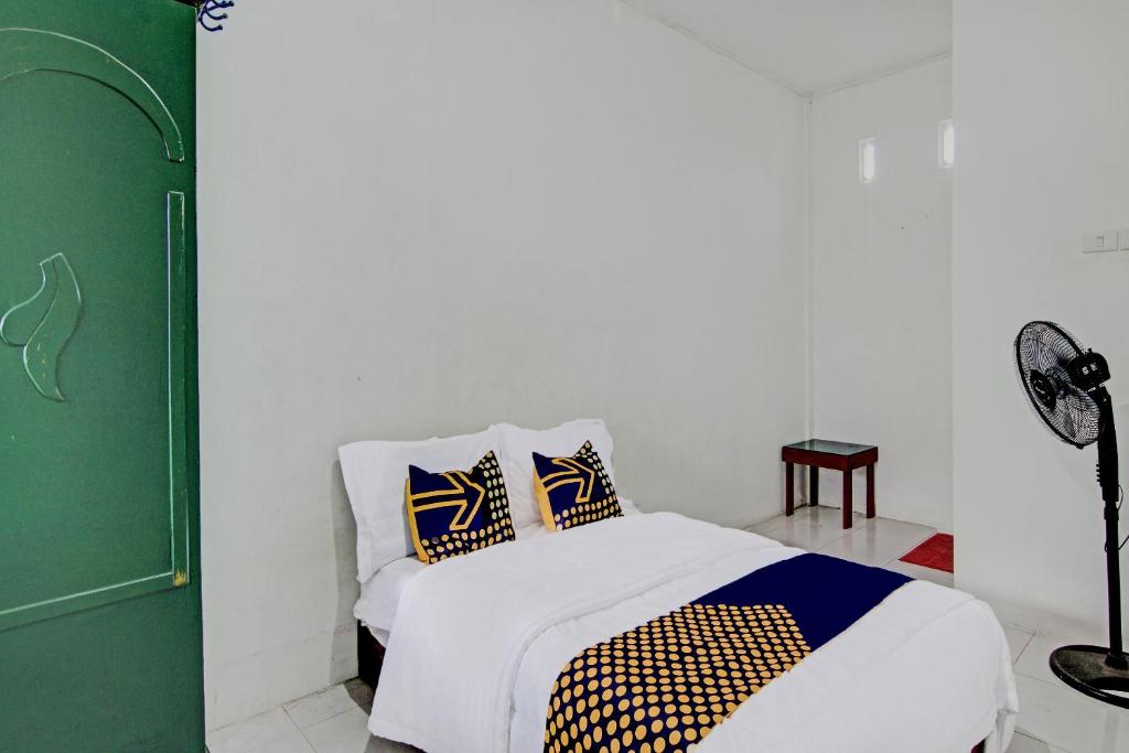 BangkinangSPOT ON 91950 Guest House TekNong Syariah的一间卧室配有一张带两个枕头的床