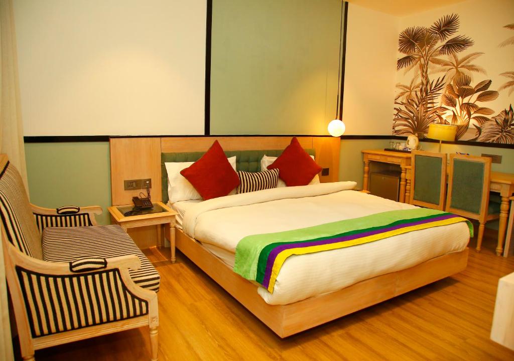 新德里AMARA HOTEL的一间卧室配有一张大床和彩虹毯子