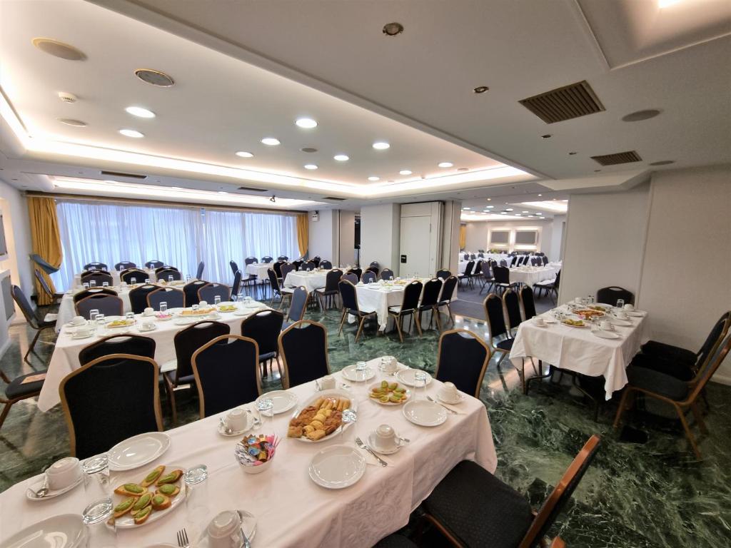 比雷埃夫斯萨沃伊酒店的宴会厅配有白色的桌椅
