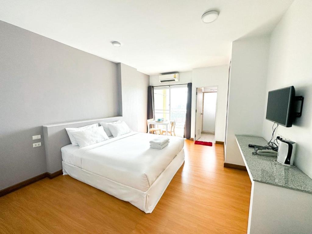 曼谷The Island Resort的酒店客房设有白色的床和电视。
