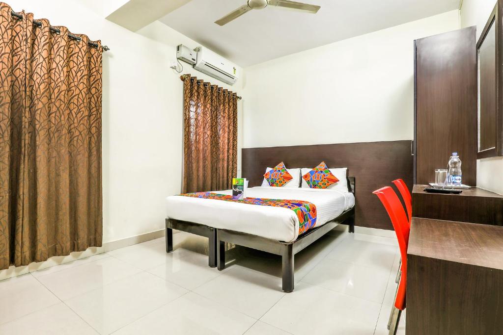 班加罗尔FabHotel RMS Comforts Yeshwantpur的一间卧室配有一张床和一张橙色椅子
