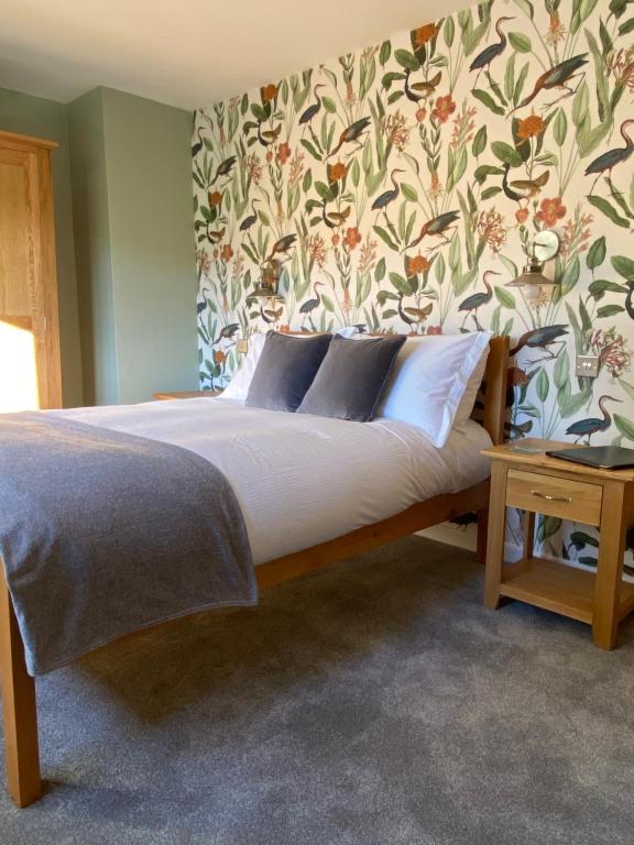 WeobleyMarshpools Bed & Breakfast - Licensed near Weobley village的一间卧室配有一张带花卉壁纸的床