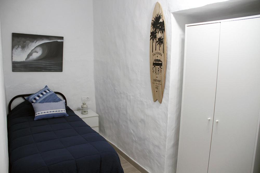 加尔达尔Apartamentos MENBAU的卧室配有一张床,墙上有标志