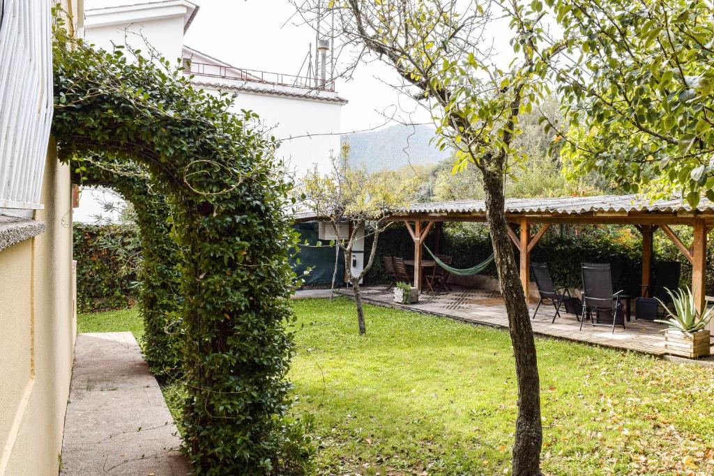 贝萨卢Can Camps Besalú Alojamiento con jardín privado的常春藤带盖的门道,通往带院子的房子