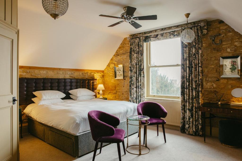 斯坦福德王冠酒店的一间卧室配有一张带紫色椅子的床和窗户。