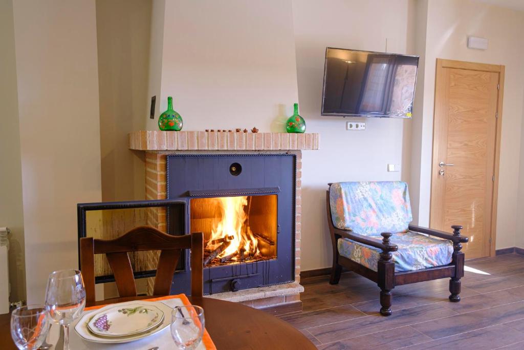 Casa Rural Cristina的客厅设有壁炉、桌子和椅子