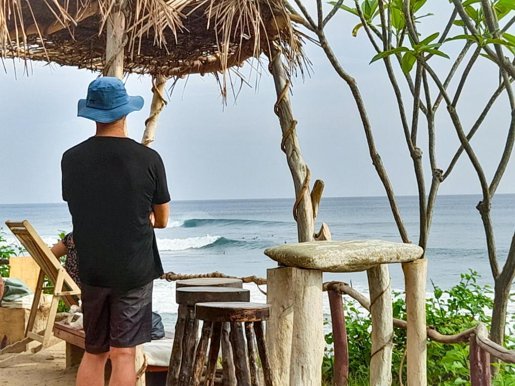 波波约Popoyo Surfcamp的站在海滩上看海洋的人