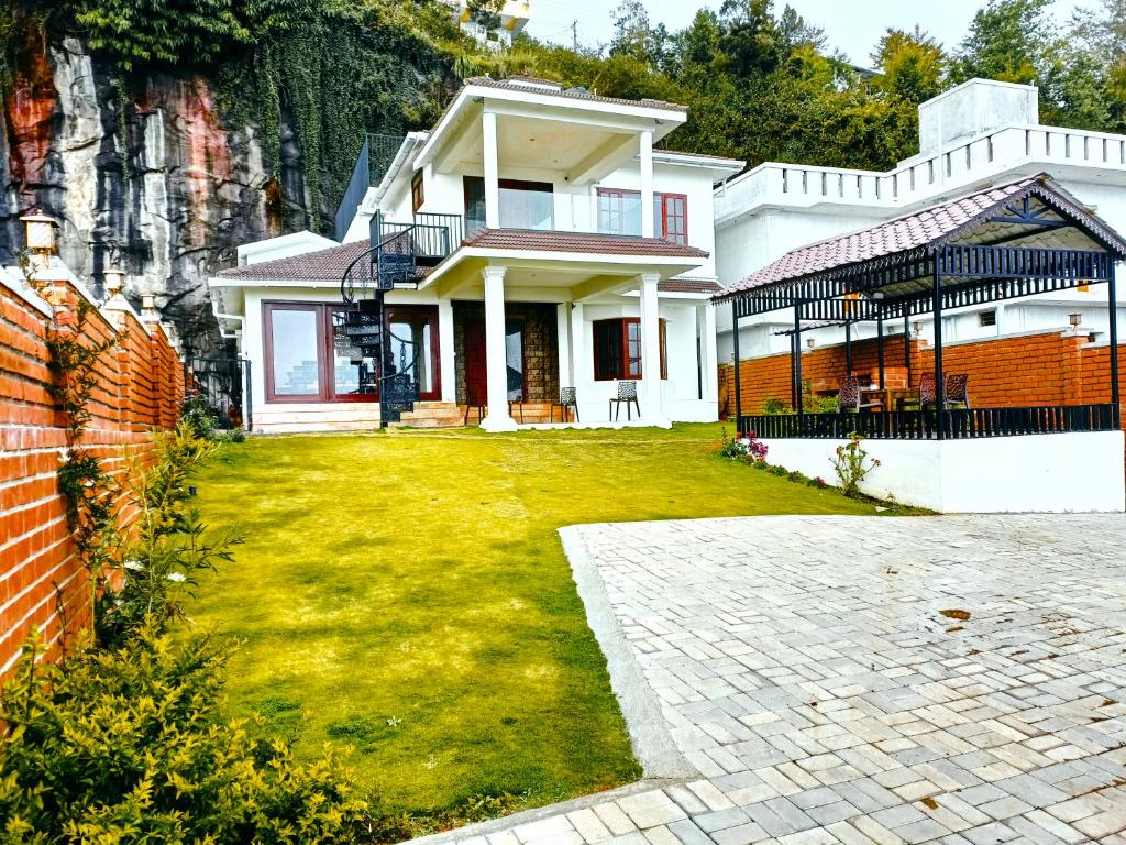 科代卡纳尔Villa de Montana的一座带草地庭院的大型白色房屋